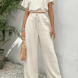 Elegant beige tweedelig modieus setje met getextureerd T-shirt en broek met wijde pijpen