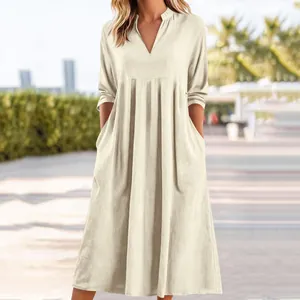 Dettaglio dell'abito estivo in lino beige chiaro con scollo a V e tasche laterali