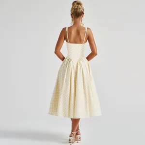 Back view of a yellow gingham French style midi dress with open back and thin straps