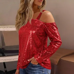 Close-up detail of the shimmering red sequin fabric on an off-shoulder long-sleeve top