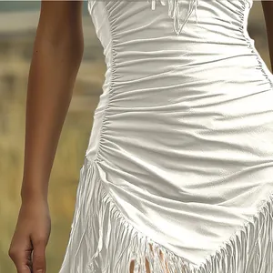Vista dettagliata dell'abito bianco drappeggiato con eleganti finiture a frange.