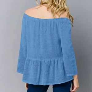 Vista posteriore dettagliata di un elegante top blu a spalle scoperte con balze