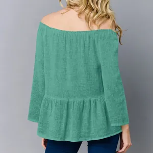 Vista posteriore di un elegante top da donna con spalle scoperte in cotone e lino color petrolio