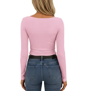 Back view of a pink ribbed long-sleeved knit top paired with classic blue jeans