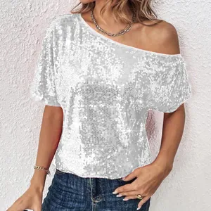 Close-up detail of shimmering silver sequins on a loose-fit one-shoulder party top.