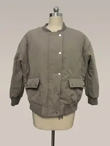 Close-up detail of a women's khaki quilted jacket with metal buttons and ribbed cuffs