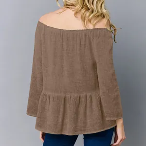 Vista posteriore di un elegante top a maniche lunghe marrone con spalle scoperte da donna