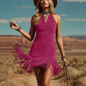 Detalle de un vestido de gamuza magenta con flecos en un paisaje desértico soleado.