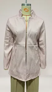 Close-up detail of a pink herringbone jacquard wool coat shown on a professional mannequin