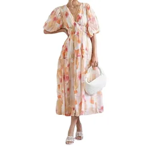 Boho midi-jurk met bloemenprint, gesmokte taille en pofmouwen getoond op een model.