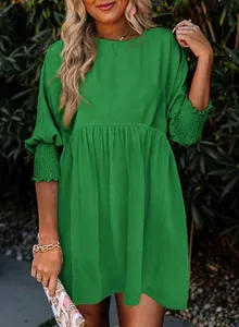 Robe verte décontractée à col rond avec poignets smockés et jupe à plusieurs niveaux.