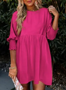 Vue détaillée de la robe fuchsia avec poignets smockés et taille à plis élégants.