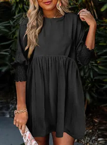 Vue détaillée d'une robe décontractée noire avec poignets smockés et tissu texturé.