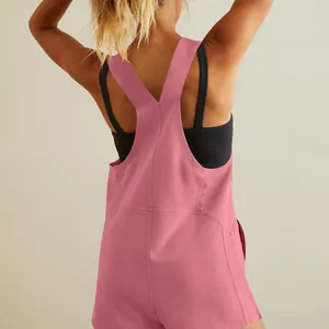 Back view of a casual pink sleeveless romper with wide straps and black sports bra