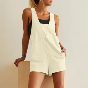 Front view of a stylish cream sleeveless romper featuring a deep V-neck and front pockets