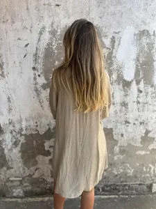 Back view of a casual women's beige cotton linen long sleeve shirt with textured fabric