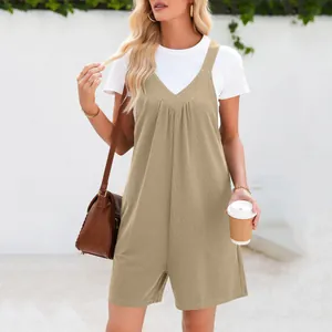 Détail de tenue d'été avec une combinaison kaki à col en V et un t-shirt blanc classique.
