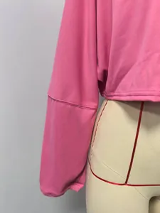 Close-up detail showing the sleeve stitching and hem on a vibrant pink cropped crewneck sweatshirt.