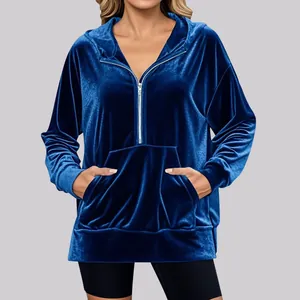 Detailed macro view showing the soft texture of a blue velvet half-zip hoodie with pocket