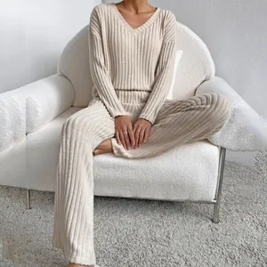 Detalle de un conjunto de punto acanalado beige con jersey de cuello en V y pantalón
