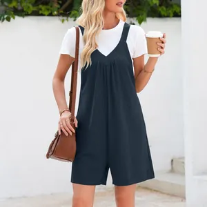 Détail du combishort bleu marine à col en V avec t-shirt blanc et sac à pompons