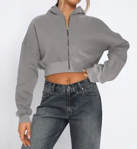 Detail view of a grey cropped zip-up hoodie featuring ribbed cuffs and soft fleece lining.