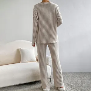 Vista posterior de un conjunto de punto acanalado beige para mujer con pantalón ancho