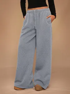 Detalle completo del pantalón de chándal gris de pierna ancha con cintura elástica y cordón