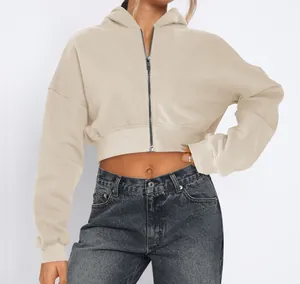 Close-up of a beige cropped zip-up hoodie with fleece lining on a street style model.