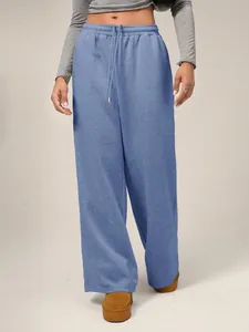 Vista detallada de los pantalones deportivos anchos de forro polar azul con cordón para mujer
