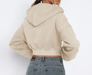 Close-up back view of a cropped sand-colored hoodie with thick fleece and ribbed hem.
