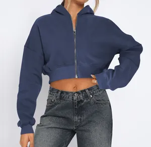 Detail of cropped blue zip-up hoodie with fleece lining and casual street style.