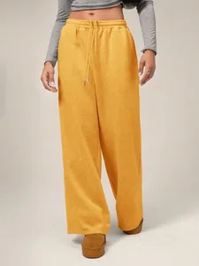 Vista macro detallada de los pantalones de chándal amarillos anchos con cordón ajuste