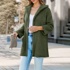 Woman wearing a loose green plush hooded cardigan in an urban street setting
