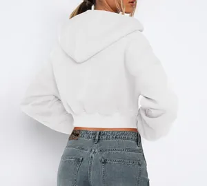 Detailed back view of a white cropped hooded sweatshirt paired with stylish denim jeans