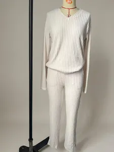 Vista detallada de un conjunto de punto acanalado crema para mujer en maniquí