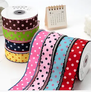 Close-up of 2.5cm scalloped grosgrain ribbons with white polka dots in various colors