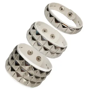 Detail showing single, double and triple rows of silver pyramid studs on white leather.