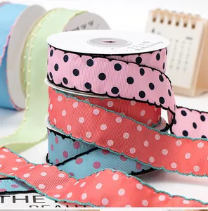 Close-up detail of 2.5cm scalloped grosgrain ribbon with polka dots for DIY craft projects