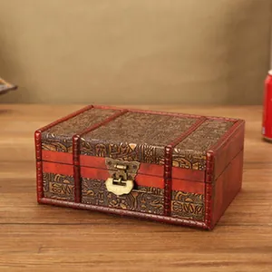 Close-up detail of a vintage wooden storage box with intricate carvings and metal latch