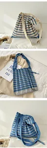 Detail view of blue and beige striped pleated knitted shoulder bag with wide strap.