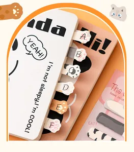 Close-up of cute cat paw shaped index tabs applied to a notebook edge for labeling.