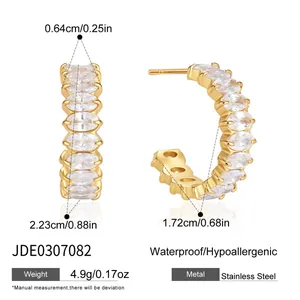 Detail view of gold-plated stainless steel C-shaped hoop earrings with oval cubic zirconia