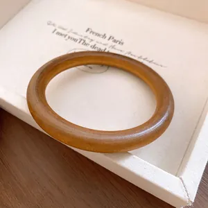 Detailansicht eines vintage braunen runden Armreifs mit glatter, holzähnlicher Harztextur