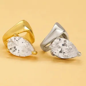 Close-up of twisted line ear clips with pear-cut cubic zirconia in gold and silver