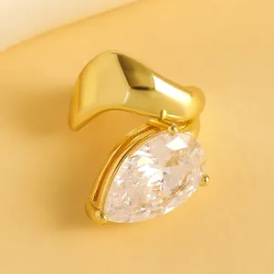 Close-up of a gold teardrop zircon ear cuff with elegant twisted metal lines.