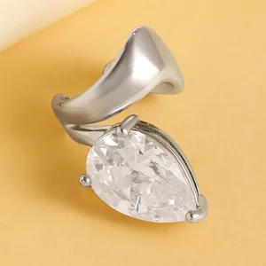 Detail view of a silver twisted ear cuff featuring a large pear-shaped clear gemstone.