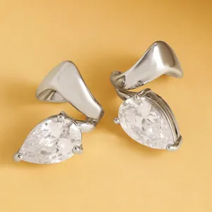 Close-up of elegant silver-colored water drop zircon ear clips with twisted metal lines