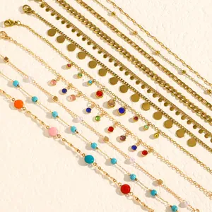 Close-up detail of gold stainless steel anklets with colorful beads and disk charms