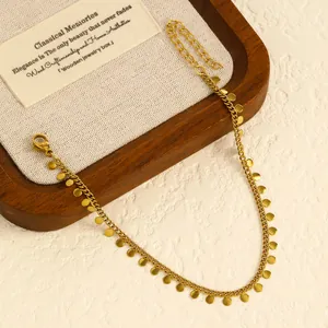 High-quality detail shot of a gold stainless steel anklet with tiny round disc pendants.